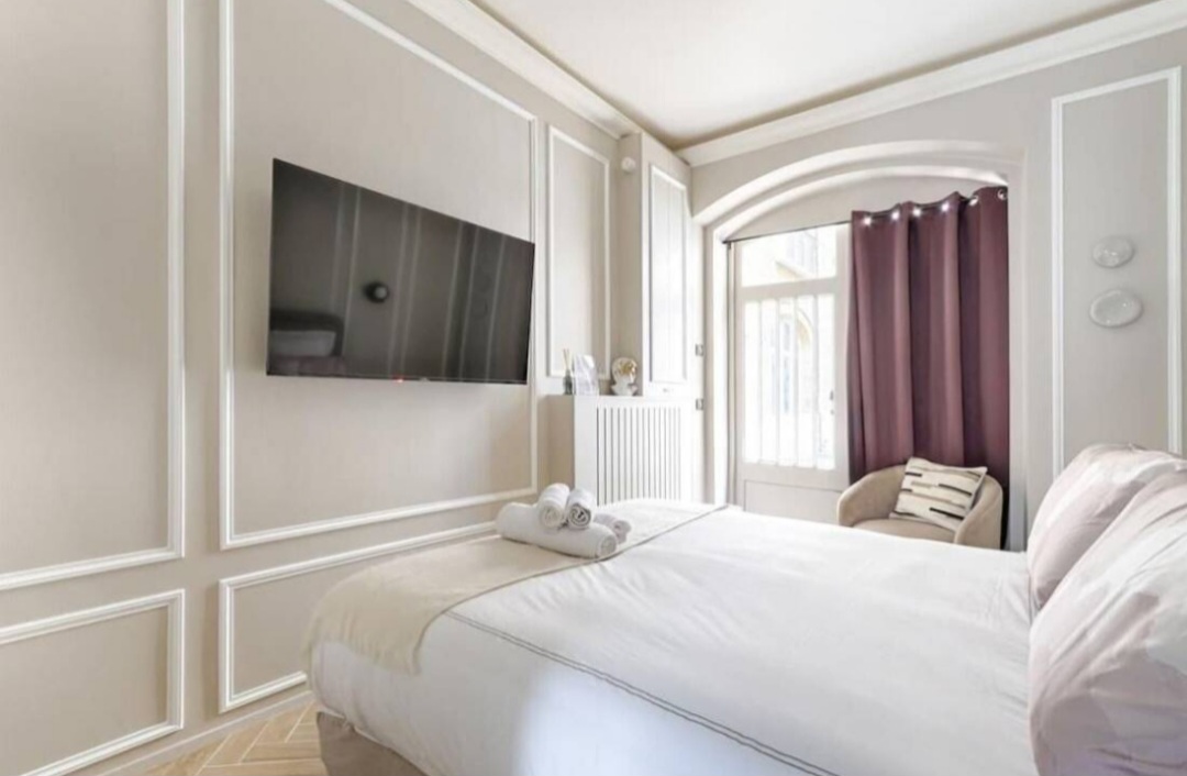 Studio interior with wall-mounted TV, moulded panelling and herringbone parquet