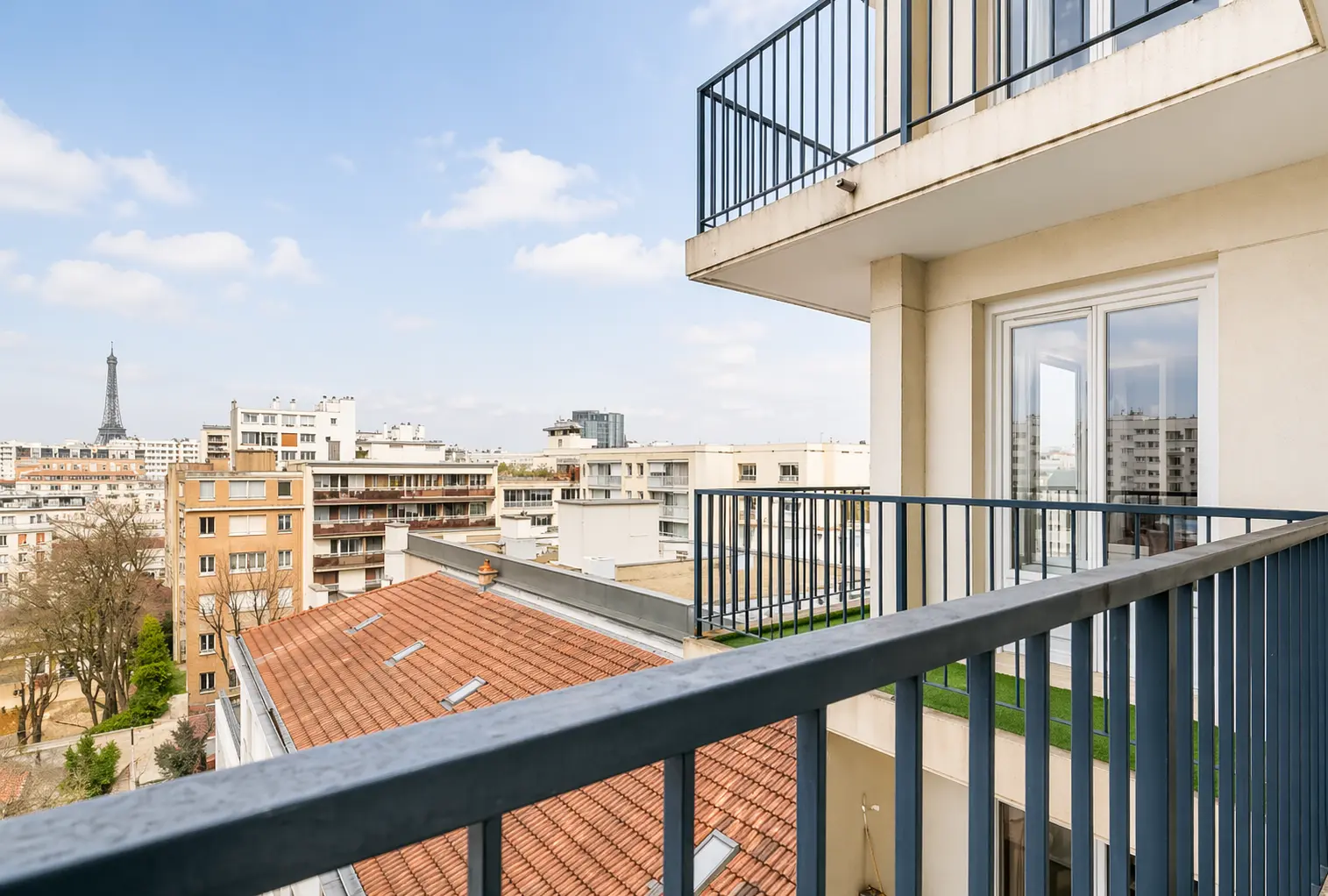 View from the balcony railing with the Eiffel Tower against the city skyline