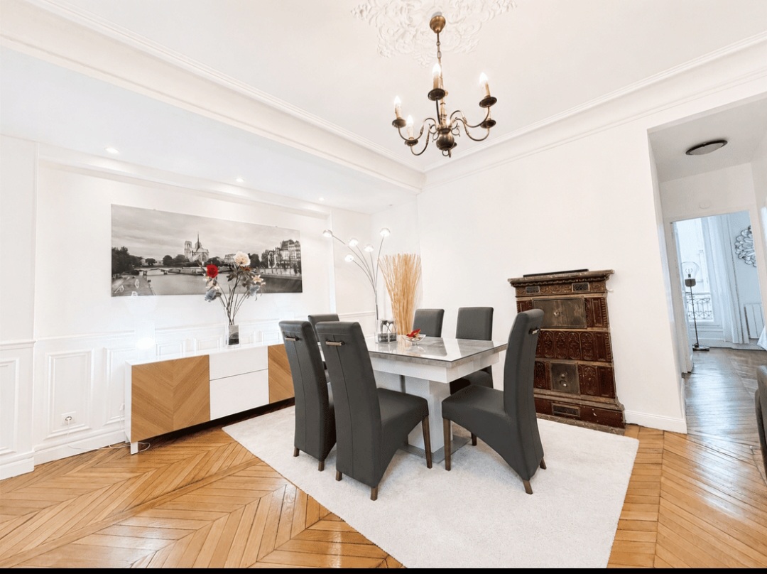 Elegant dining area for six with chandelier, panelling and herringbone parquet — Le Marais · Paris 4e