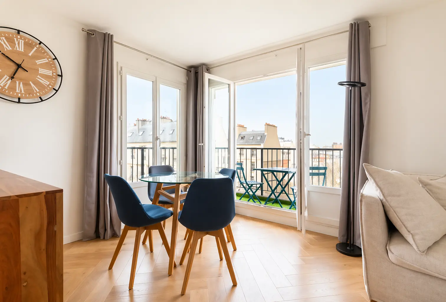 Living room opening onto a balcony with the Eiffel Tower in the distance