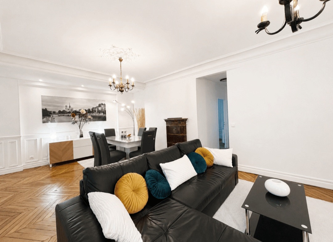 Spacious 30 m² living room with leather sofa, dining area and mouldings in Le Marais — Le Marais · Paris 4e