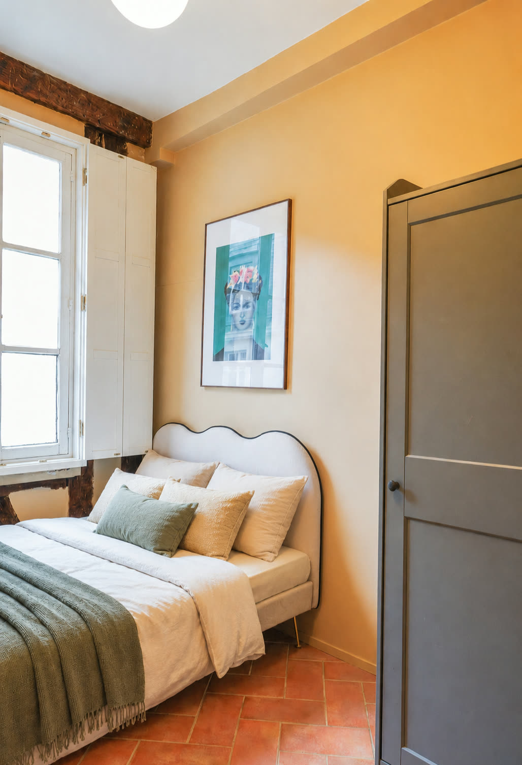 Bedroom with tall Parisian window, soft linen and terracotta tiled floor