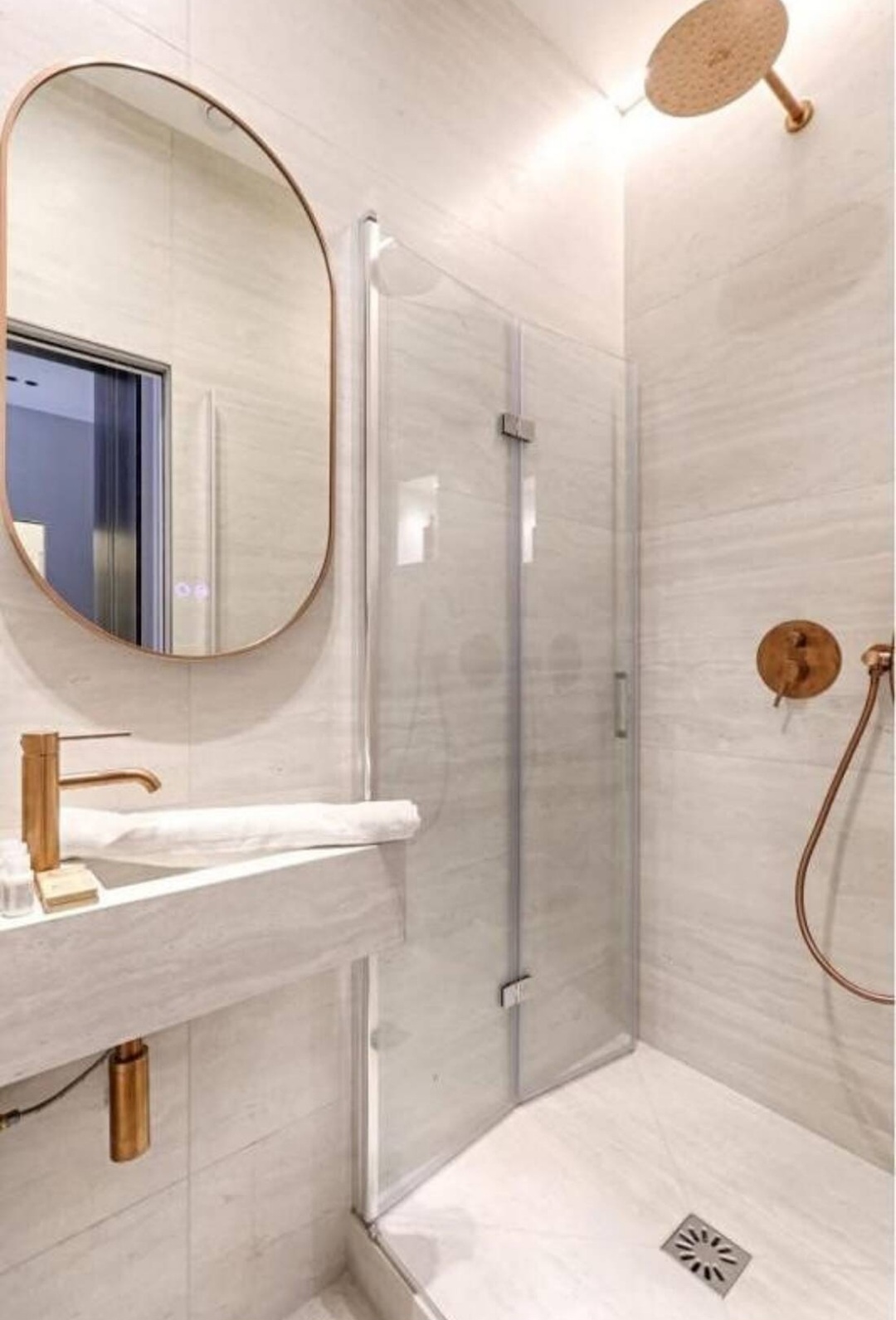 Modern bathroom with walk-in shower, stone tiles and brushed brass fittings