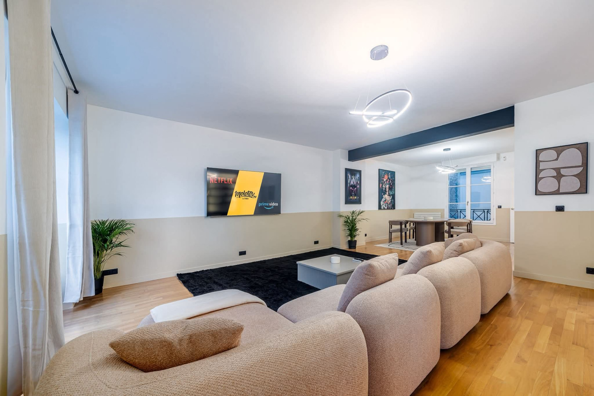 Living room opening onto the dining area with wall-mounted TV — Paris 7e, Paris, France