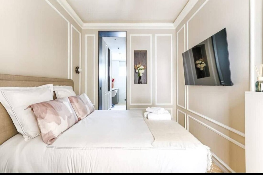 Double bed with view through to the modern bathroom of the Paris 7 studio