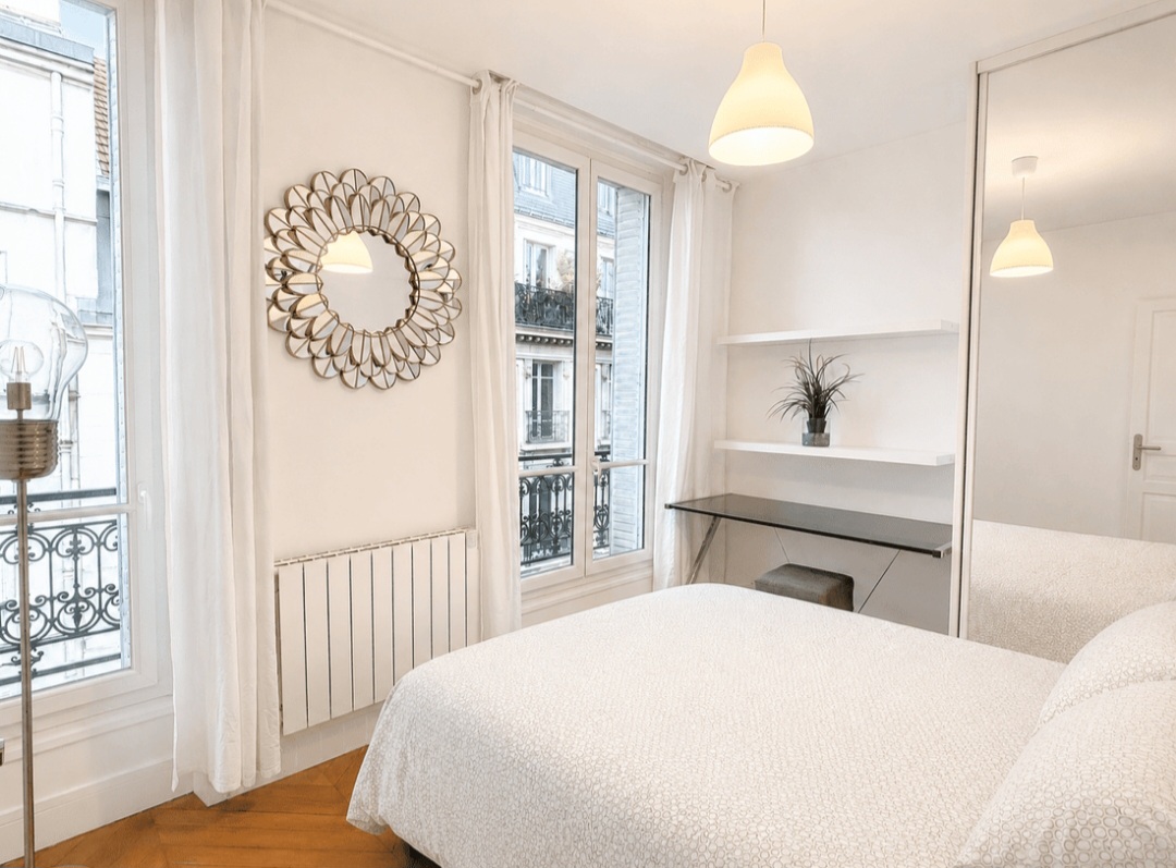 Second bedroom with twin beds, desk and two windows over a quiet Marais street — Le Marais · Paris 4e