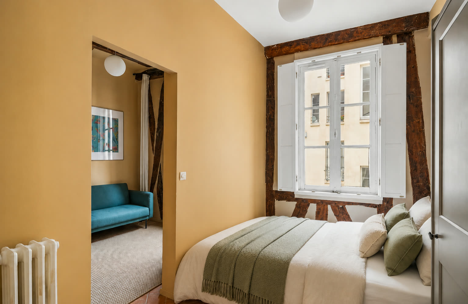 Bedroom with storage and view through to the living room of the Le Marais studio