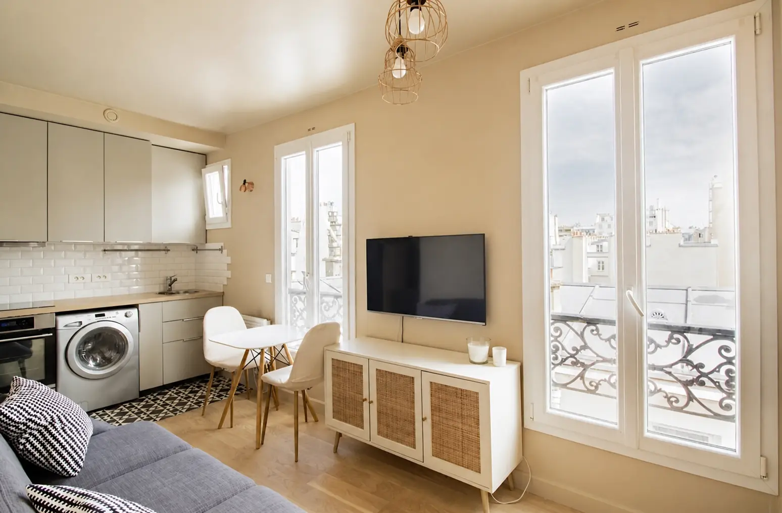 Living area with television, sideboard and open kitchen beyond — Rue Amélie, 7e arrondissement de Paris, Paris