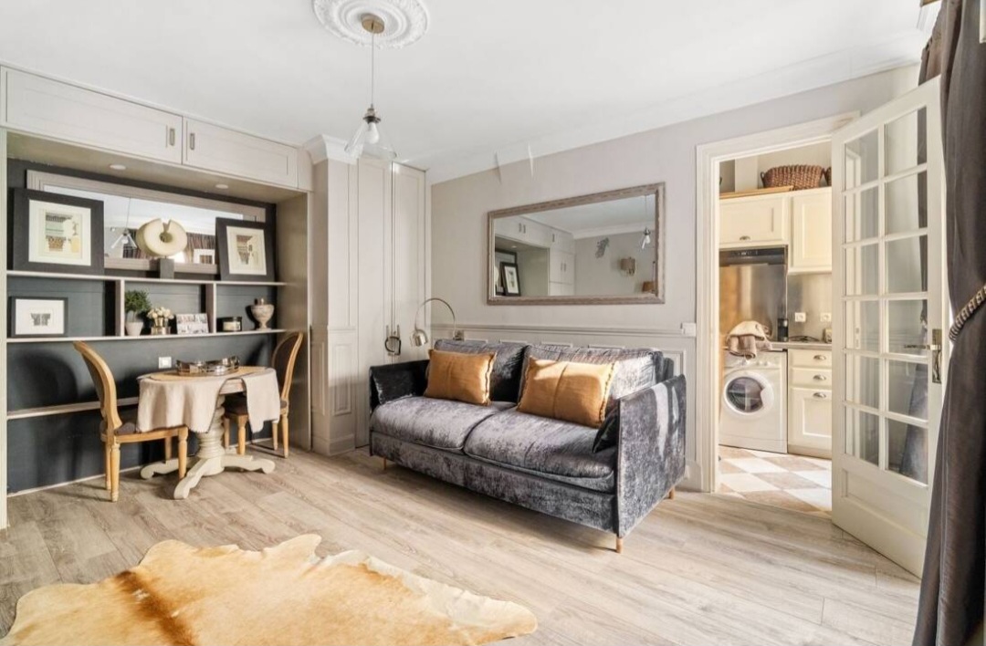 View from the living area through French doors to the separate equipped kitchen — Rue du Bac · Paris 7e